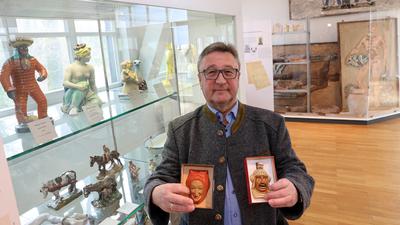 Der Daxlander Brauchforscher und Sammler Jürgen  Stoll sucht im Majolika-Museum am Ahaweg in Karlsruhe Keramiken mit närrischen Motiven. Die Miniaturlarven in seiner Hand aus Stolls eigenem Besitz sind in der Majolika entstanden.