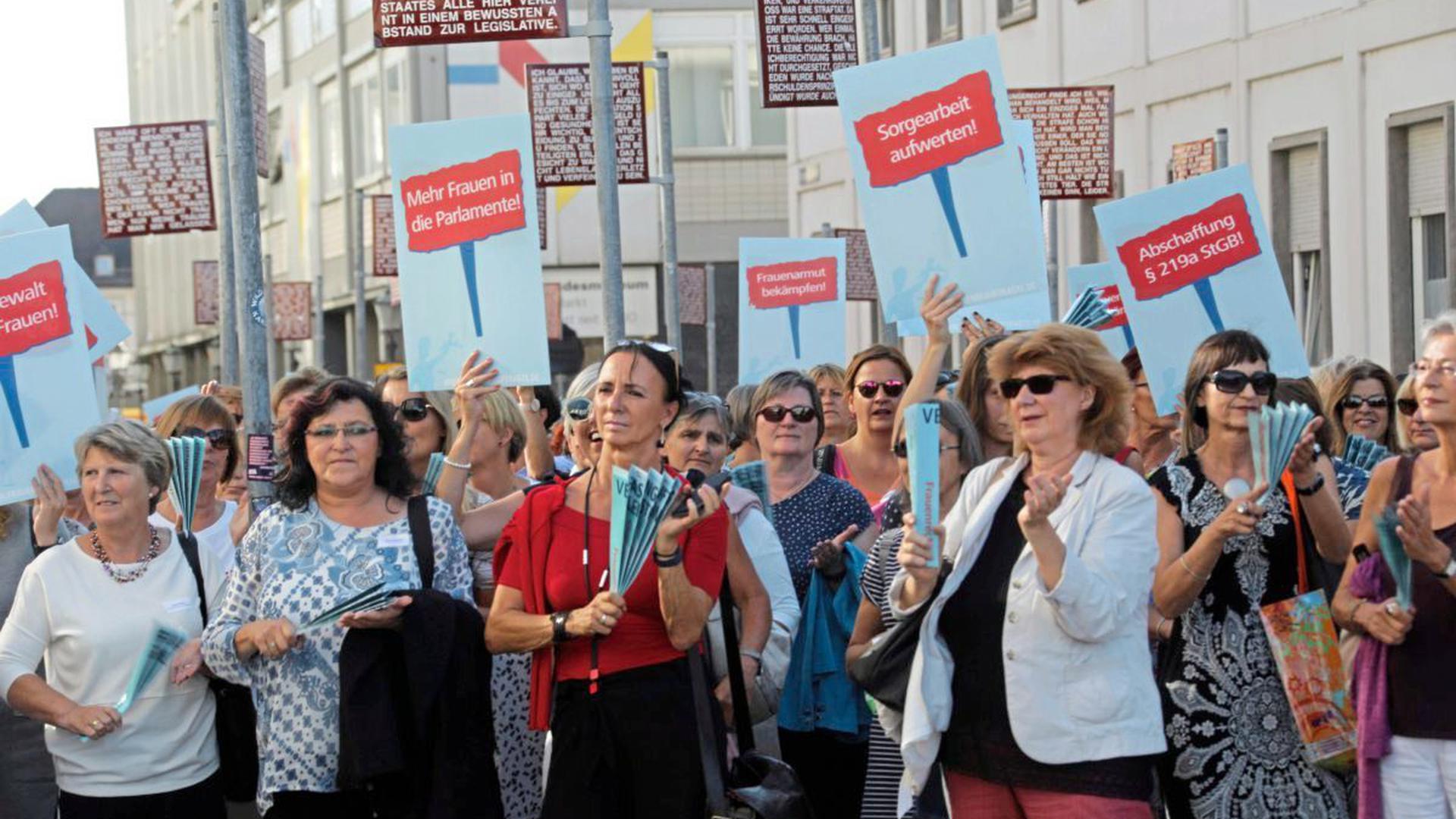 Eine Gruppe Frauen demonstrieren mit Schildern auf dem Platz der Grundrechte