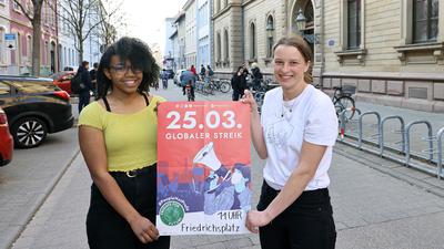 Am 24.03.2022 stehen Lilith Diaw (links) und Jana Krüger mit einem Plakat zum Globalen Klimastreik am 25. März 2022 vor dem Fichte-Gymnasium in Karlsruhe.