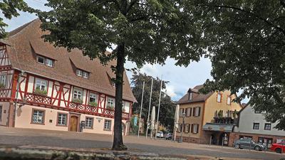 Am 10. August 2021  spiegelt sich das frisch restaurierte Rathaus in Grötzingen nur im Wasser des Brunnens auf dem Platz. Hochwassermarken verraten aber, wie verheerend früher Überflutungen durch die Pfinz waren.