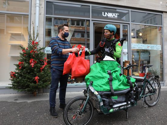 Übergabe vor dem Geschäft: Unikat-Inhaber Andreas Preißler händigt dem Radkurier Bestellungen aus. Die Lieferung ist für die Kunden im Stadtgebiet kostenfrei.  