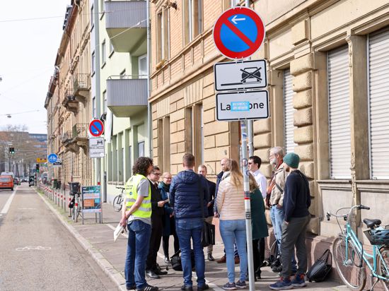 Eine Gruppe von etwa zehn Personen steht auf dem Gehweg der Kapellenstraße in Karlsruhe und berät sich.