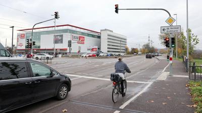 Am 6.12.2022 passiert eine Radlerin die Ampel, die extra für Radfahrer an der Durlacher Allee auf Höhe des Fußgängerüberwegs zum Bahnhalt in der Mitte der Straße hängt.