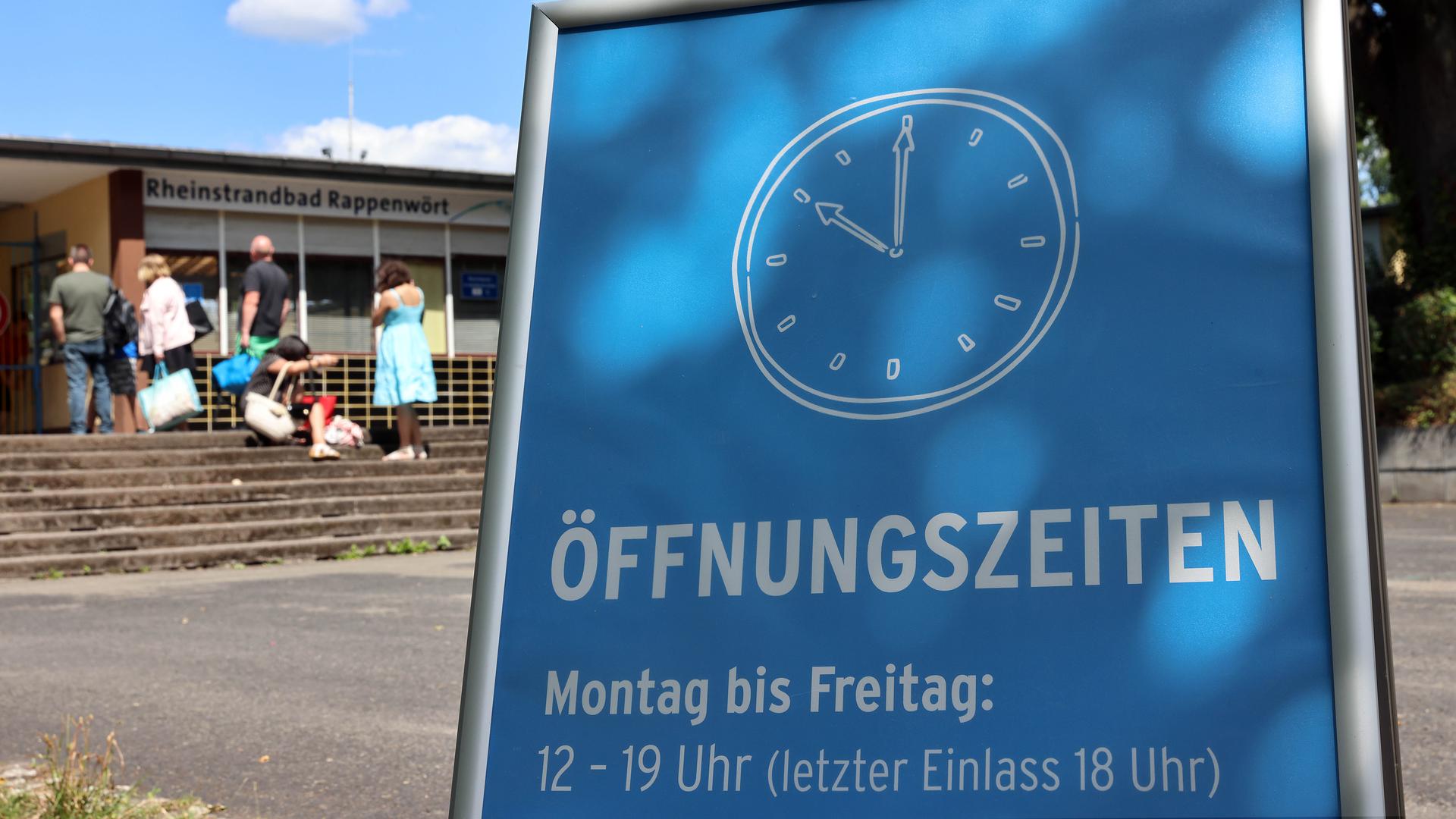 Ein Schild vor dem Freibad Rappenwört mit geänderten Öffnungszeiten.