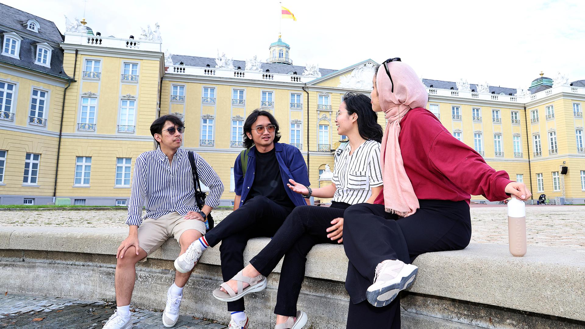 Die indonesische Gruppe „The Fox, The Folks“ um Fahry Aziz, Fadjar Kurnia, Jessica Lovia und Darina Maulana (von links) sitzt vor dem Karlsruher Schloss.