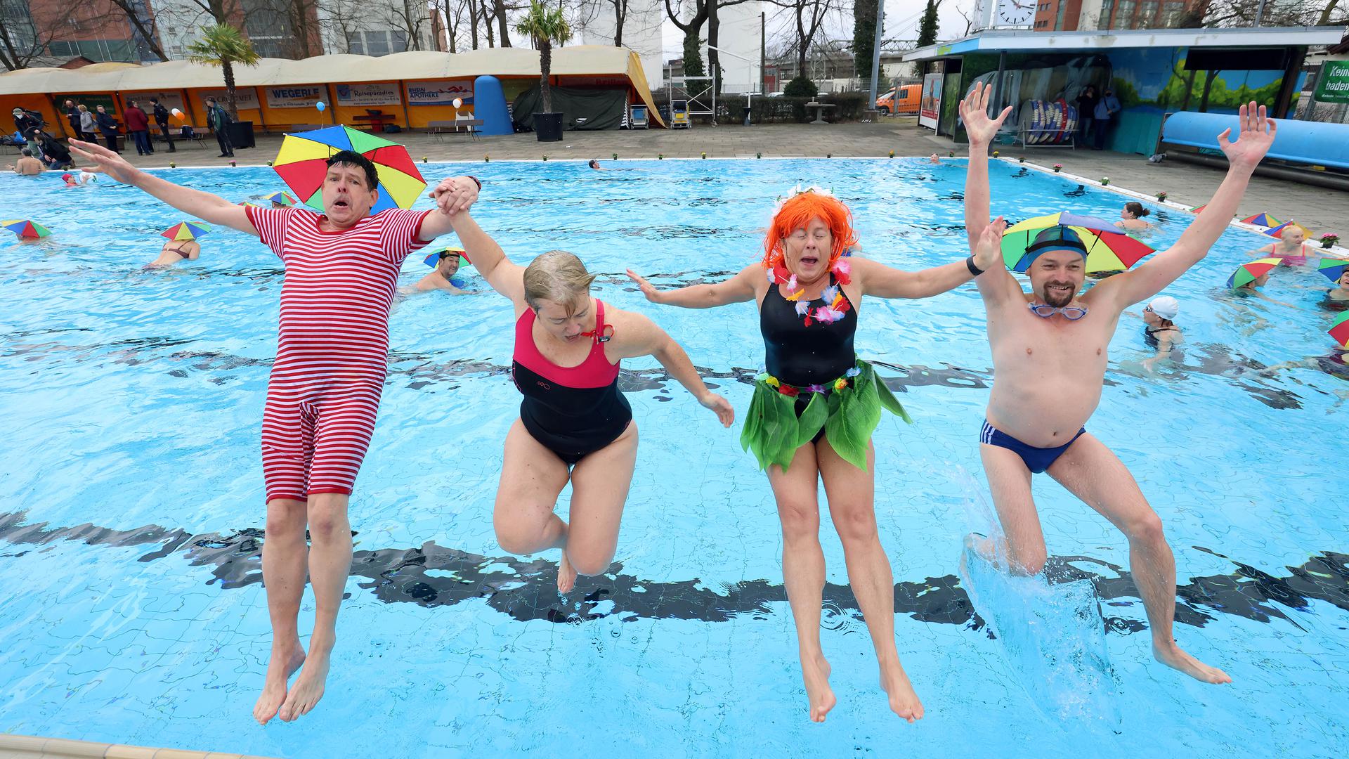 vier verkleidete Menschen springen ins Wasser