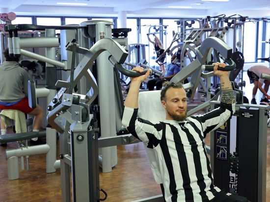 Mann trainiert in einem Fitnessstudio.
