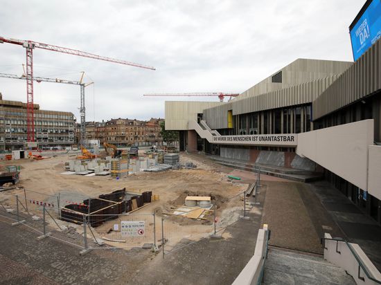 Am Badischen Staatstheater gibt es viele offene Baustellen. Vor dem Haus sind Kräne und Bagger im Einsatz.  Bereits vor Sommer 2022 soll der Übergangszugang fertig sein.