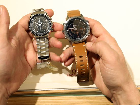 Ein Mann hält eine Smartwatch und eine klassische Armbanduhr in der Hand.