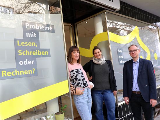 Jörg Althen, Alexa Preuß, Diana Amoroso (von rechts) stehen vor einem Schaufenster mit der Aufschrift „Probleme mit Lesen, Schreiben oder Rechnen?“