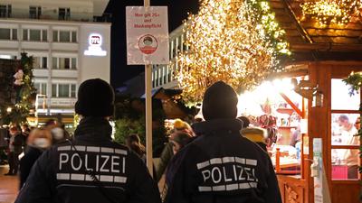 Kontrolle: Polizeibeamte zeigten am Mittwoch Abend auf dem Weihnachtsmarkt Präsenz und überprüften Abstände und Masken-Moral. Der Andrang war im Vergleich zu früheren Jahren aber gering.