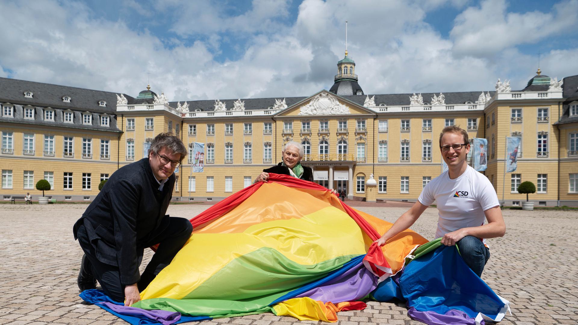 Am 5. Juni hisst das Badische Landesmuseum wieder die Regenbogenflagge auf dem Karlsruher Schlossturm. Gerlinde Hämmerle (Mitte) ist Schirmherrin des diesjährigen Christopher Street Days und hier mit Museumsdirektor Eckart Köhne und CSD-Organisator Karsten Kremer zu sehen.