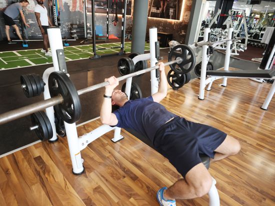 Jonas Jung trainiert in einem Fitnessstudio mit einer Gewichtstange.