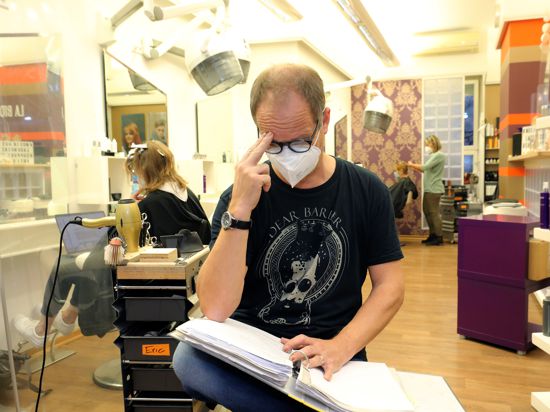 Friseur Eric Schneider in seinem Salon mit Papierkram