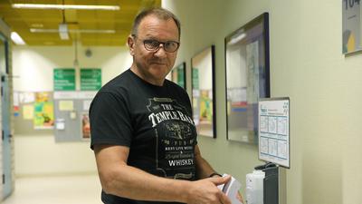 Christoph Soja füllt einen Desinfektionsmittelspender nach.