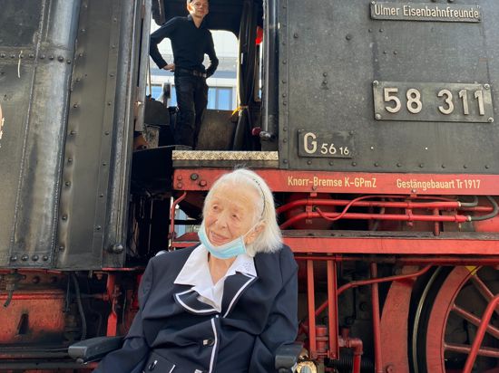 Aufeinandertreffen zweier Hundertjähriger: Gertrud Boos am Karlsruher Hauptbahnhof mit der Dampflok 58311.