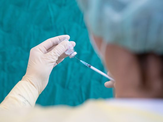 Eine Krankenschwester zieht den Impfstoff des Herstellers Moderna gegen das Coronavirus in einer gestellten Situation mit einer Spritze auf. 