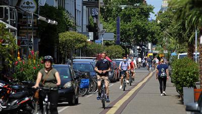 Viele Radfahrer und einige Fußgänger durchqueren die Südliche Waldstraße.
