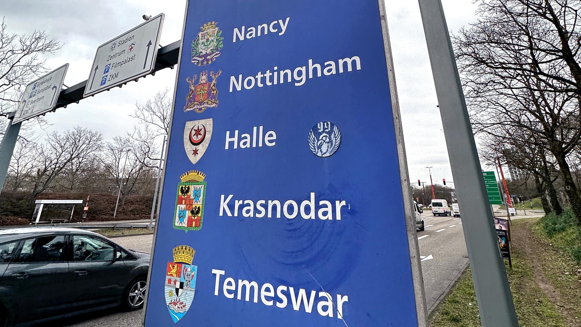 Ein Schild mit den Wappen und Namen der Städte mit denen Karlsruhe eine Städtepartnerschaft unterhält. Nancy, Nottingham, Halle, Krasnodar, Temeswar