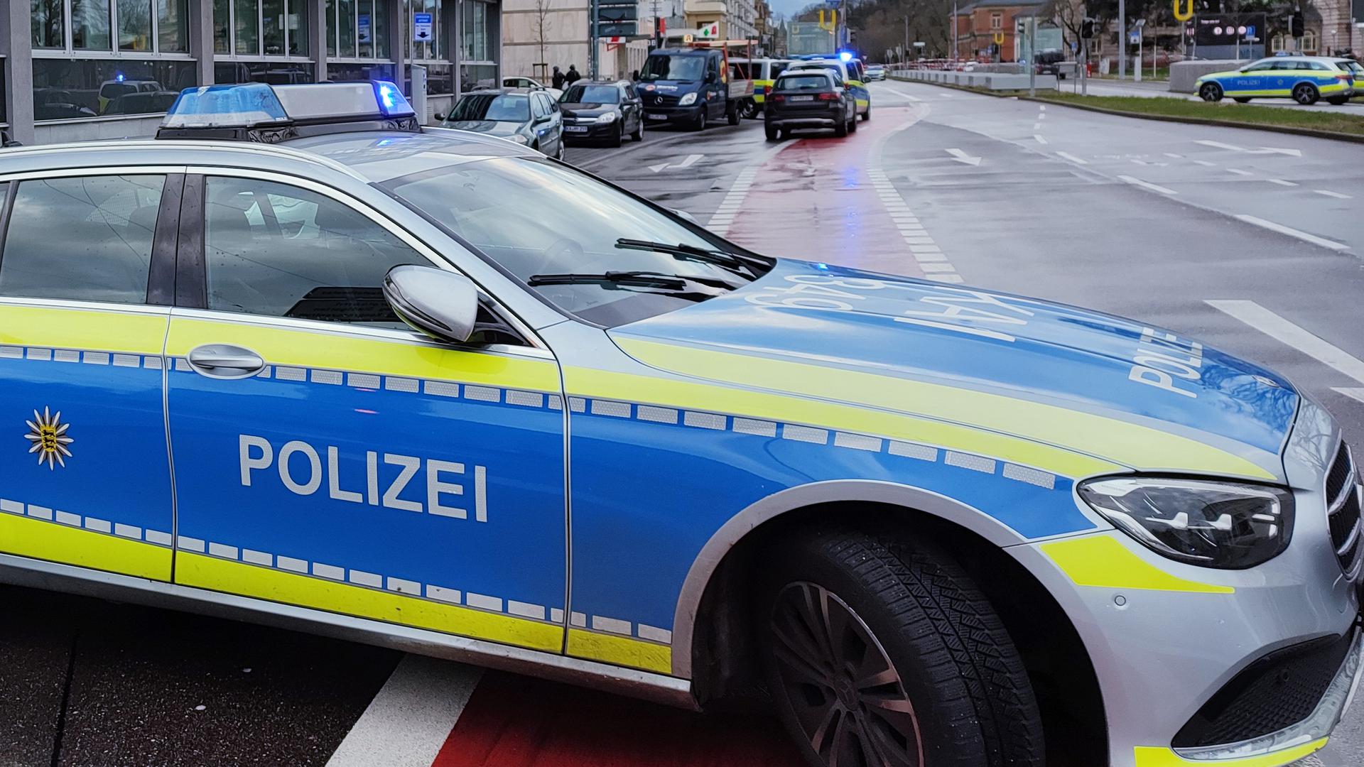 Polizeifahrzeuge stehen auf einer Straße in Karlsruhe. Die Polizei ist wegen einer Geiselnahme in einem Großeinsatz.
