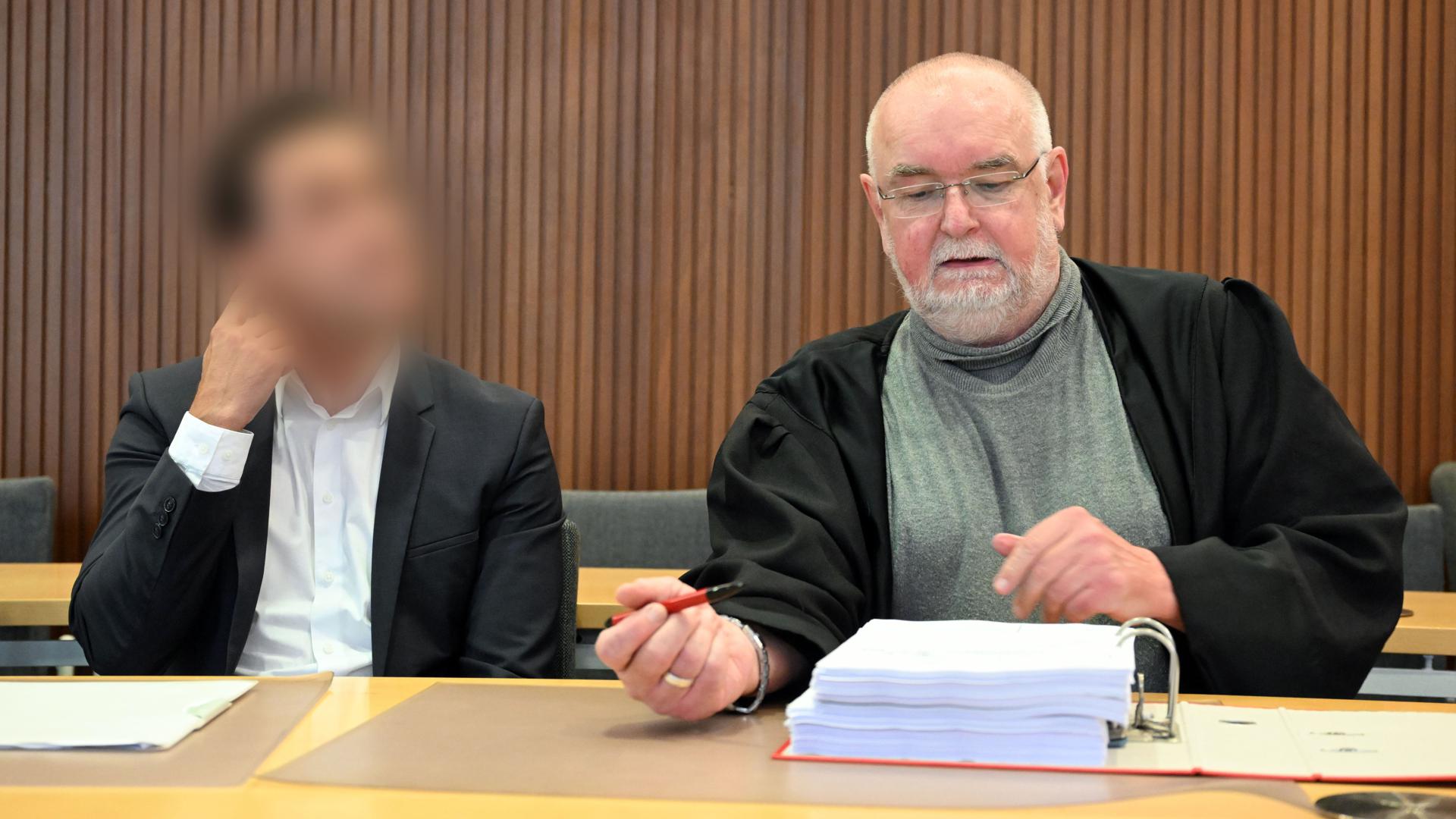 Der Angeklagte (links) im Prozess wegen eines Erpressungsversuchs wartet im Amtsgericht Karlsruhe zusammen mit seinem Anwalt Michael Urbanek auf den Beginn der Verhandlung.