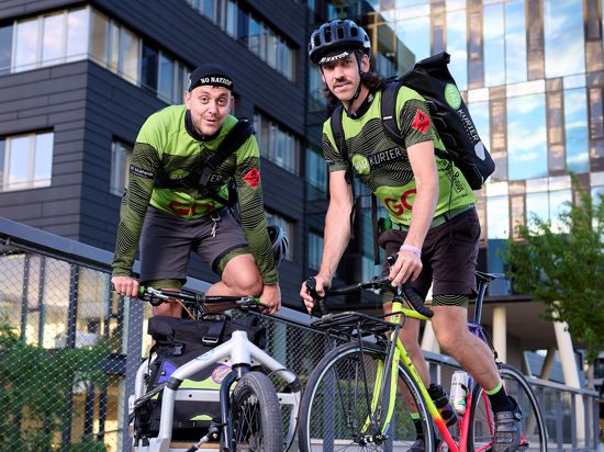 Zwei Männer Lastenrad Fahrrad Radkuriere Gebäude im Hintergrund