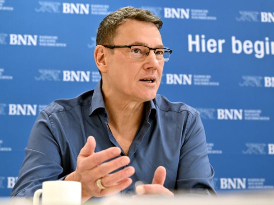 Ralph Suikat im Interview, im Hintergrund ist das BNN-Logo mehrfach zu sehen.