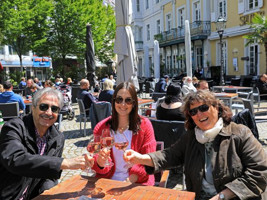 Harald, Christina und Heidi Kohnle (von links) trinken ein Glas Wein auf dem Ludwigsplatz.