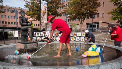 Am 26.8.2022 steht FKF-Präsident Michael Maier mit Mitstreitern zum Putzen des Narrenbrunnens am Kronenplatz in Karlsruhe im Wasser.
