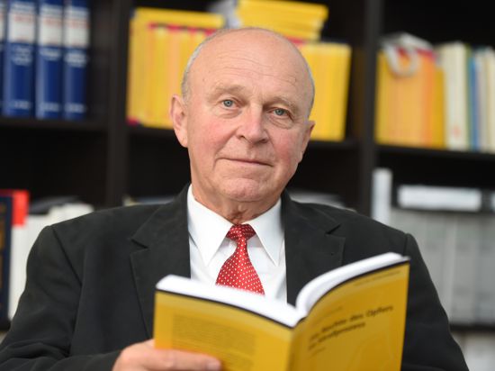 Rechtsanwalt Klaus Schroth mit Buch in seinem Büro