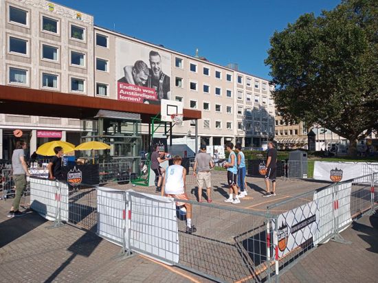 Zu Hip-Hop-Rhythmen und Black Music fliegen blau-weiß-rot gestreifte Basketbälle aus jeder Ecke des mit Absperrgittern abgegrenzten Areals auf den Korb auf dem Karlsruher Friedrichsplatz.