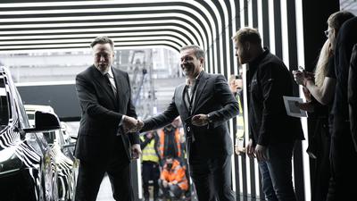 Unvergessliches Erlebnis: Der Karlsruher Rainer Puls (Mitte) bekommt von Tesla-Boss Elon Musk (links) persönlich das allererste Model Y überreicht, das in der Gigafactory des Unternehmens in Grünheide vom Band gerollt ist. 