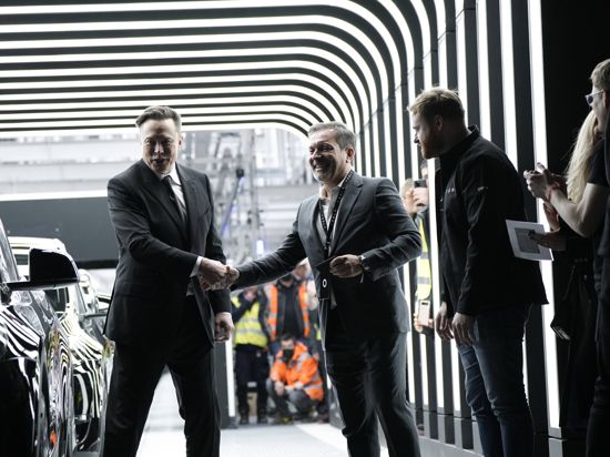 Unvergessliches Erlebnis: Der Karlsruher Rainer Puls (Mitte) bekommt von Tesla-Boss Elon Musk (links) persönlich das allererste Model Y überreicht, das in der Gigafactory des Unternehmens in Grünheide vom Band gerollt ist. 