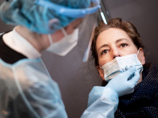 Eine Frau lässt sich in einem Corona-Schnelltest-Zentrum mit einem Nasenabstrich auf das Coronavirus testen. +++ dpa-Bildfunk +++