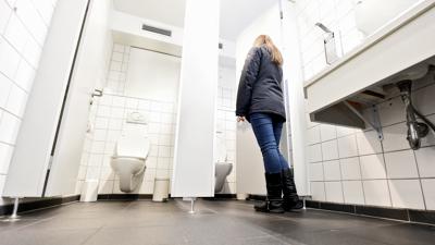 Eine junge Frau betritt eine Toilette im Schlosscafé Karlsruhe.