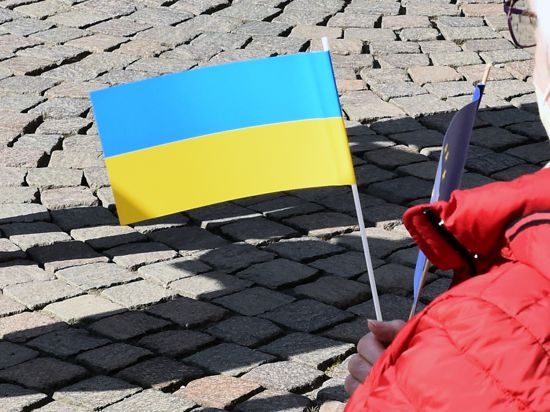 Frau hält ukrainische Flagge in der Hand