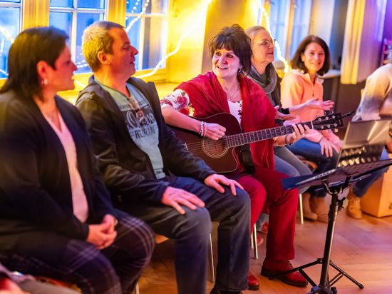 Im Karlsruher Stephanienbad singen Frauen und Männern in ungezwungener Atmosphäre leichte Lieder. Miriam Trauth begleitet die Gruppe mit der Gitarre.