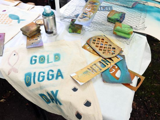 Eine mit Buchstaben und Fischerei-Symbolen besprühte Jutetasche liegt auf einem Tisch.