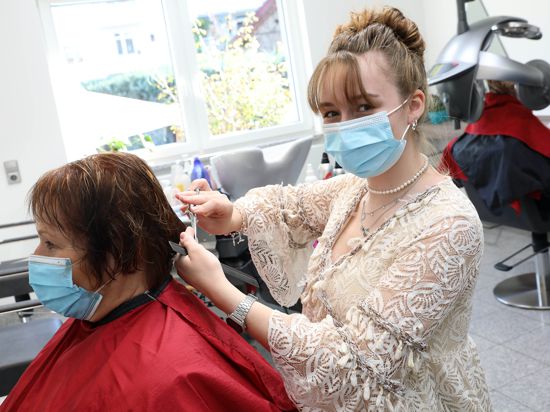 Lisa Difflipp schneidet einer Kundin im Friseursalon ihrer Familie in Durlach-Aue die Haare.