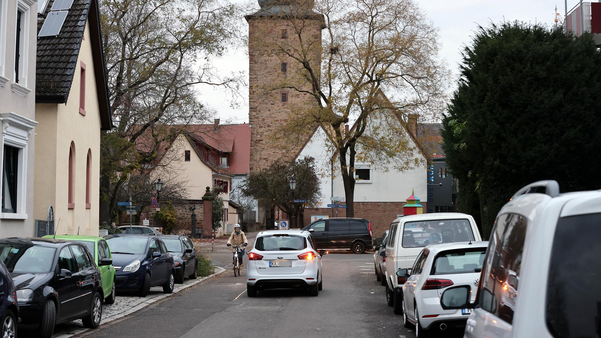 Am 5.12.2022 hat am Rand der Durlacher Altstadt eine Radfahrerin in der Basler-Tor-Straße wenig Platz zwischen parkenden Autos und einem entgegenkommenden Auto.