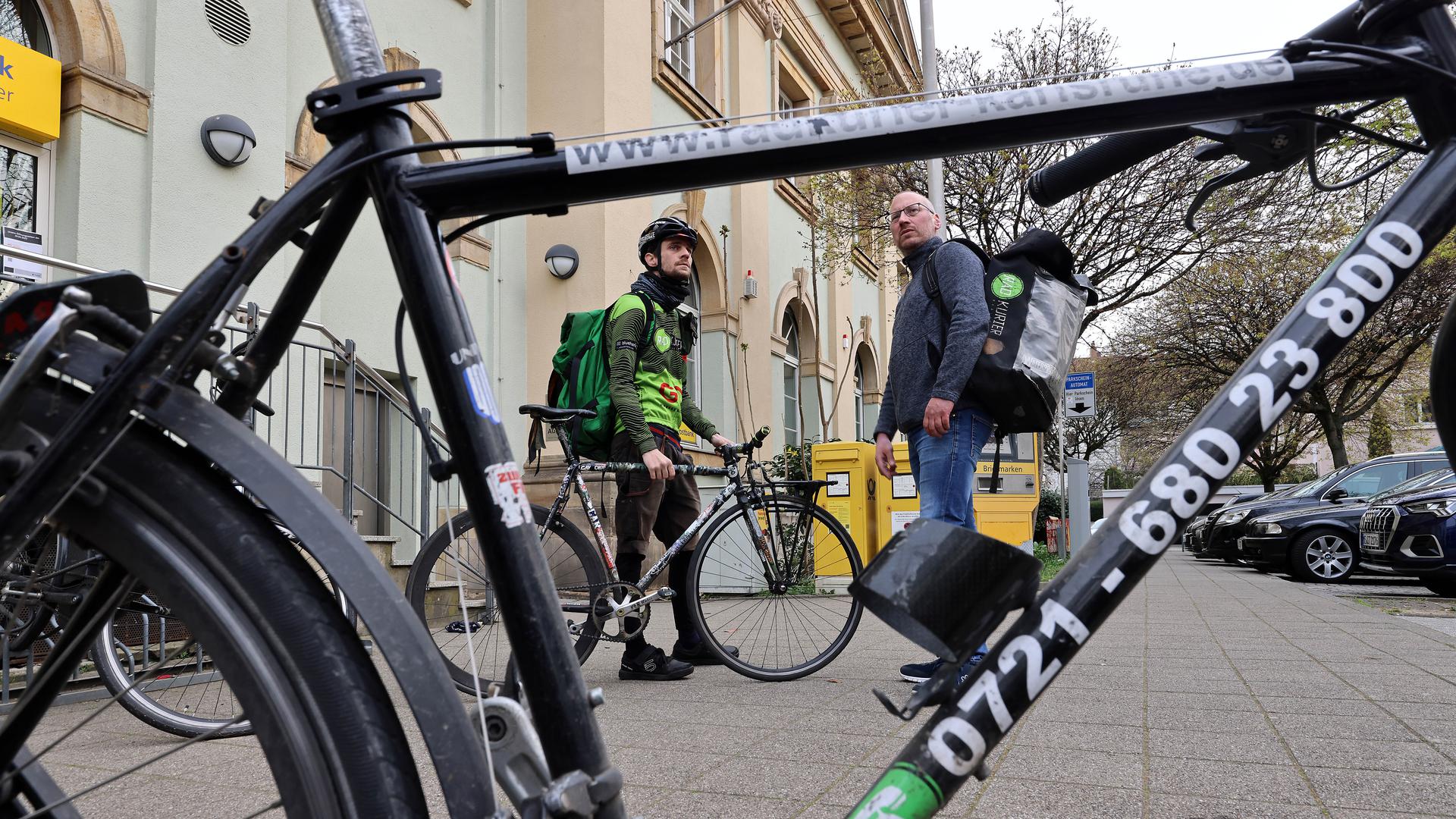 Am 29.03.2022 stehen Radkurier Julian (links) mit seinem Fixie-Fahrrad und sein Chef David Budwasch von der Firma Radkurier Karlsruhe vor der Post in Karlsruhe-Durlach.