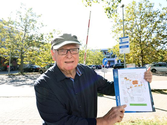 Ein Senior mit Schildmütze vor einem Supermarktparkplatz in Durlach, von dem er sich in seiner Ruhe gestört gefühlt.