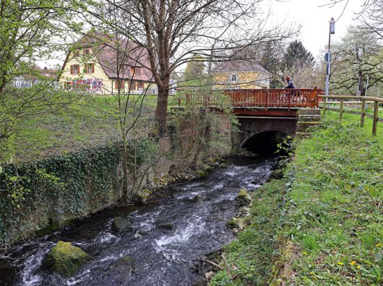 Am 5. April 2022 überqueren Fußgänger die Pfinz in Durlach bei der Obermühle.