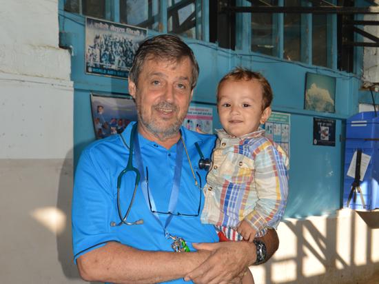 Kinderarzt Rolf-Dieter Löw mit einem Kind auf dem Arm