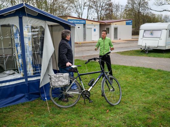 10.4.2021 Betriebsleiter Rocco Trunz, Campingplatz Durlach, mit einem Gast aus Nordrhein-Westfalen, der mit seinem Fahrrad am Vorzelt seines Wohnwagens steht