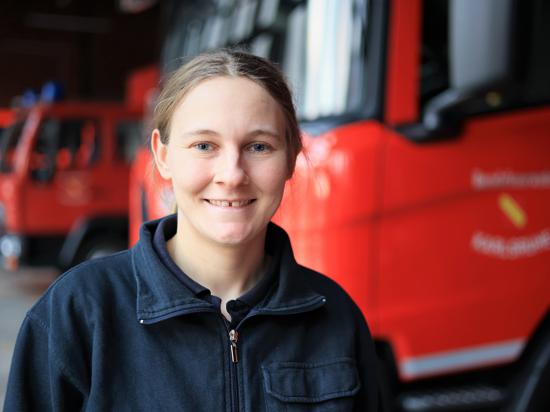 Brandrätin Michaela Hofmann von der Berufsfeuerwehr Karlsruhe steht neben einem Spezialfahrzeug in der Feuerwehrwache Karlsruhe West