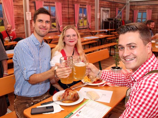 Niklas (re.), Tobias und Angela genießen Haxen und badisches Bier. Wie viele sind sie in bayerischer Tracht, Lederhose respektive Dirndl gekommen. 