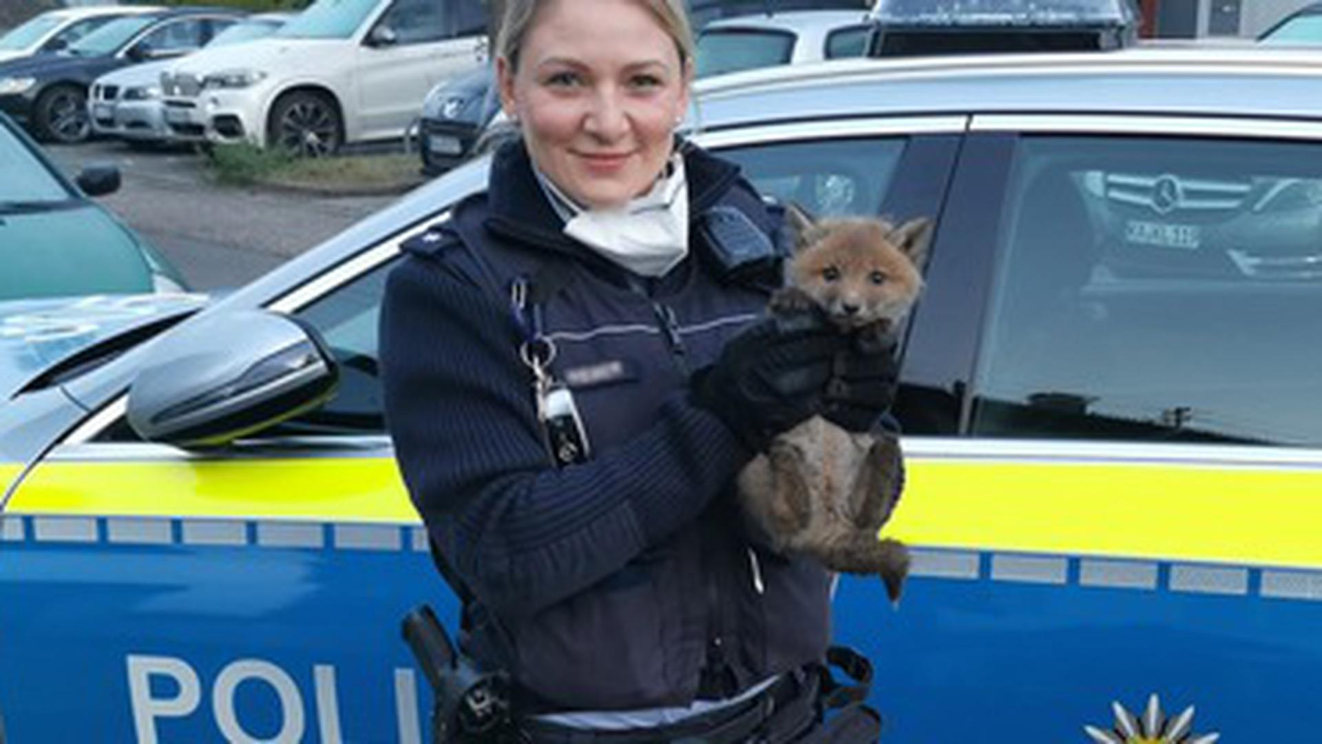 Polizistin mit Babyfuchs auf dem Arm