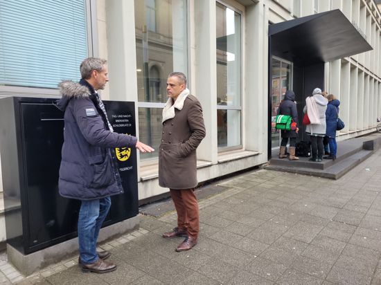 Zwei Männer unterhalten sich vor dem Amtsgericht Karlsruhe.