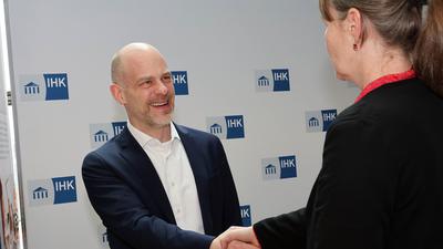 IHK-Hauptgeschäftsführer Arne Rudolph reicht IHK-Pressesprecherin Claudia Nehm die Hand.